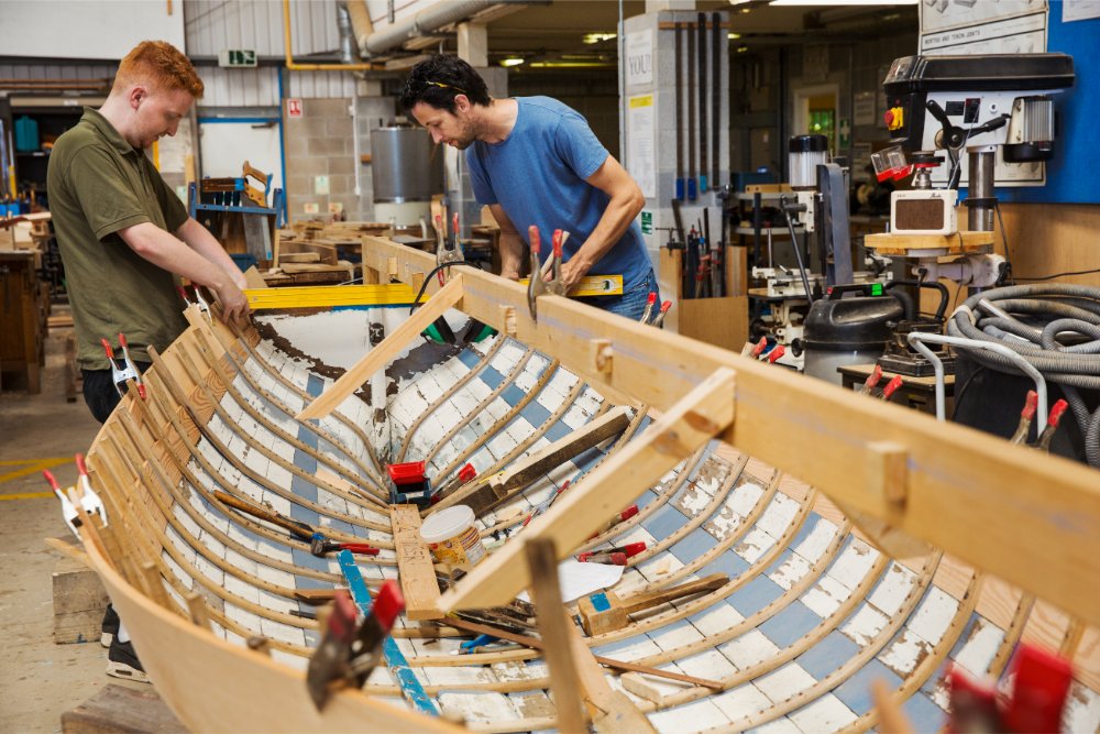 two men in a boat builder s workshop working toge 2023 11 27 05 14 34 utc