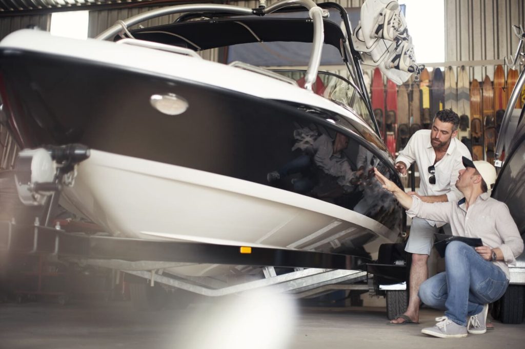 two men inspecting a boat in a workshop HF6P3QG